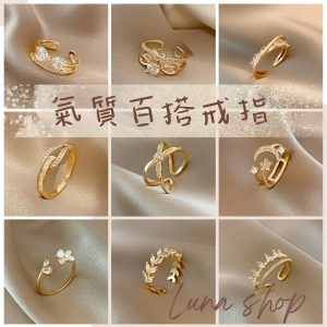 尾戒推薦：交叉镂空结构镶嵌多颗水钻，戒圈刻有「卍」字符号，摆放深灰绒布背景凸显光泽｜防过敏S925材质｜招贵人防小人设计
